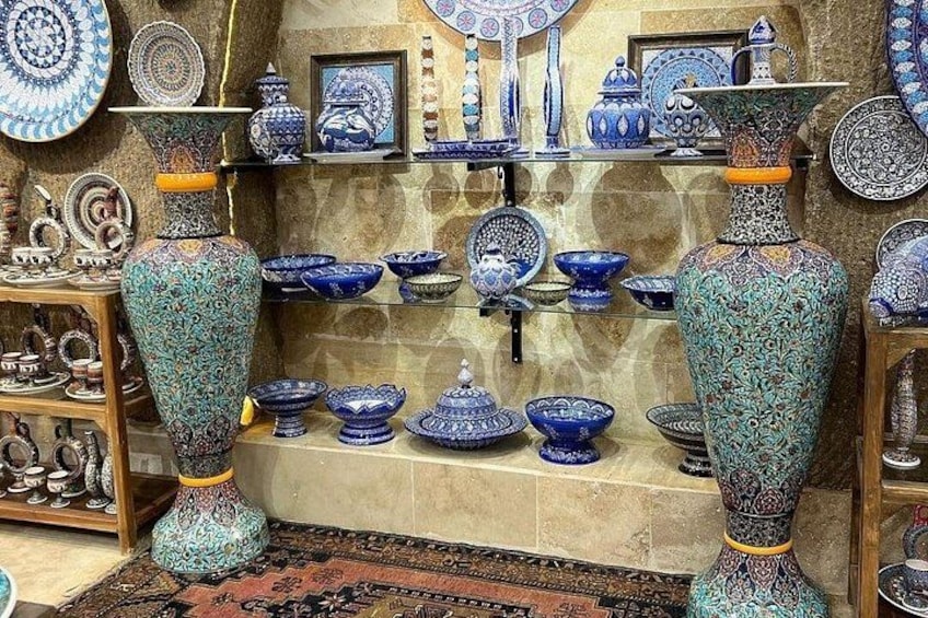 Una exposición de intrincados jarrones y cuencos de cerámica azul y verde sobre estantes y soportes. 4
