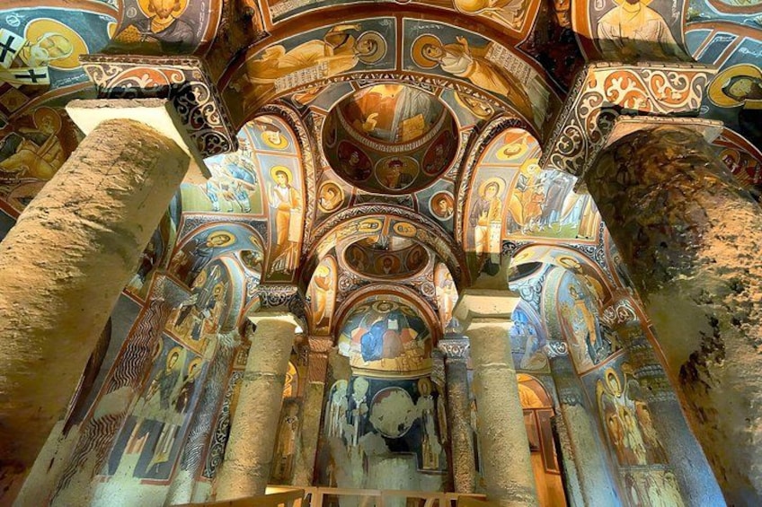 Detalle del interior de un edificio histórico con columnas ornamentales y frescos coloridos. 1