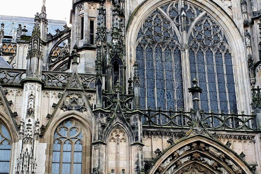 Une cathédrale de style gothique, caractérisée par ses sculptures complexes en pierre, ses grandes fenêtres à vitraux et ses décorations métalliques ouvragées. 3