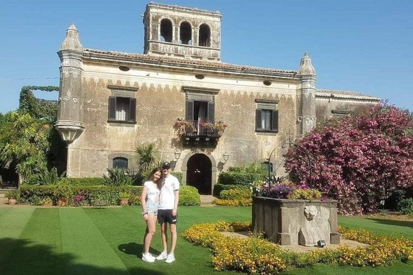 A historic building with a bell tower, surrounded by well-maintained gardens and a fountain. 4