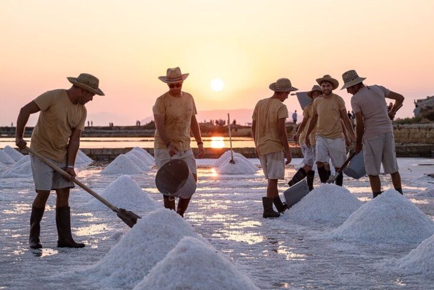 Trabajadores cosechando sal al atardecer. 2