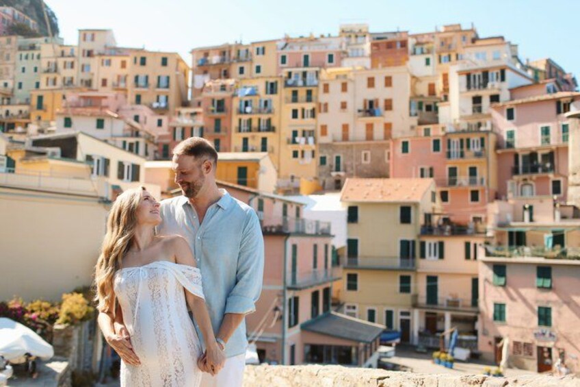 A couple standing on a rooftop with a view of colorful buildings in the background. 4
