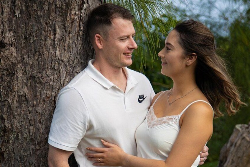 A couple embracing near a tree. 4