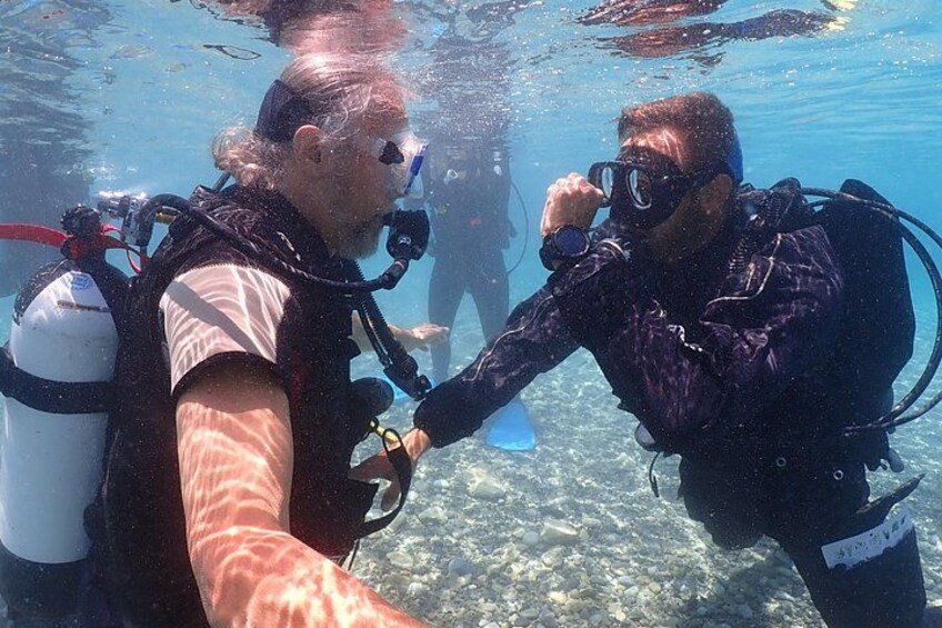 Two scuba divers underwater, one taking a selfie with the other. 3