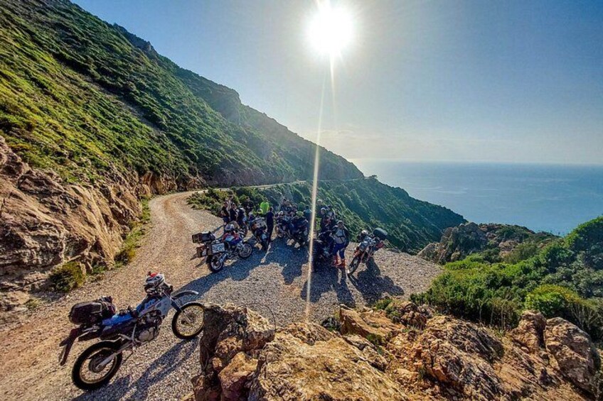 Un grupo de motociclistas en una carretera de montaña con vista al océano. 4