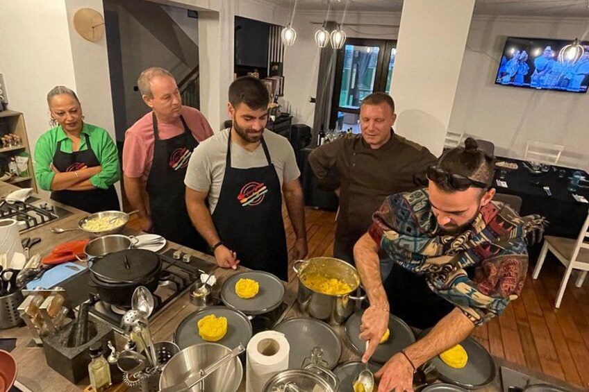 A group of people cooking in a kitchen with various cooking utensils and ingredients. 2