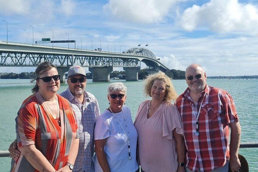 Un grupo de personas de pie junto a un puente sobre el agua. 4