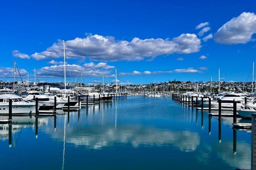 Una marina con barche ormeggiate ai pontili, acqua calma e un cielo azzurro sereno con nuvole. 3