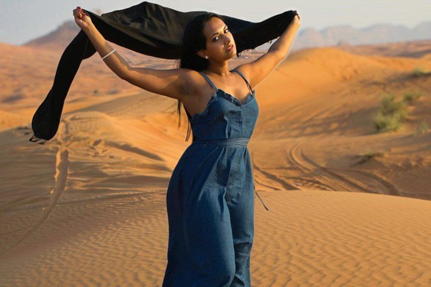 Une personne se tient debout dans un désert, avec des dunes de sable en arrière-plan. 1
