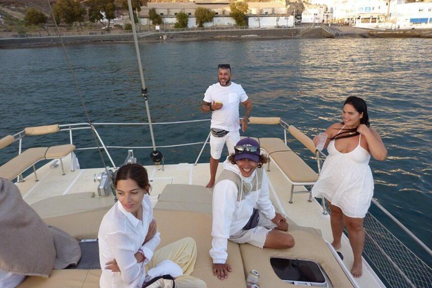 Un groupe de personnes se trouve sur un bateau, la mer est calme et on aperçoit un quai au loin. 3