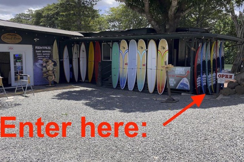 A surf shop with surfboards on display and an arrow pointing to the entrance. 3