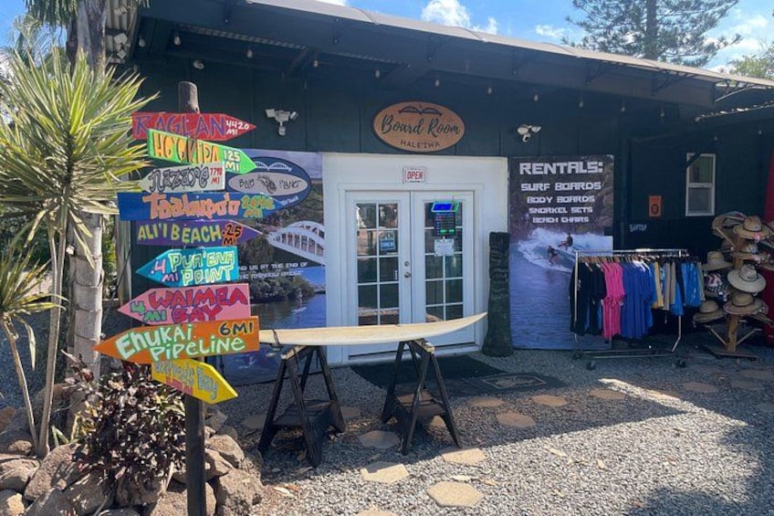 A boardwalk with colorful signs, a rental shop, and a palm tree. 5