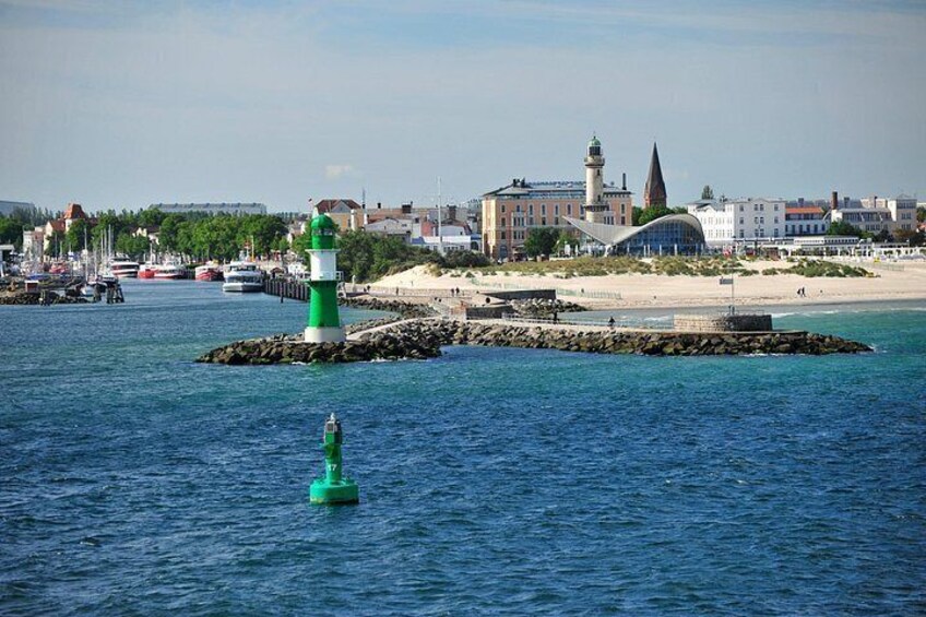 A coastal town with a lighthouse, a pier, and a sandy beach. 2