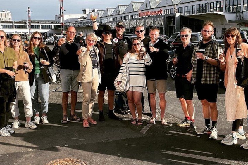 En gruppe mennesker står på en gade med en bygning i baggrunden. 4