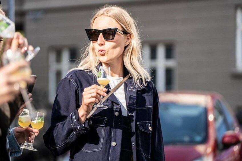 En person holder en drik og bærer en denimjakke. 2