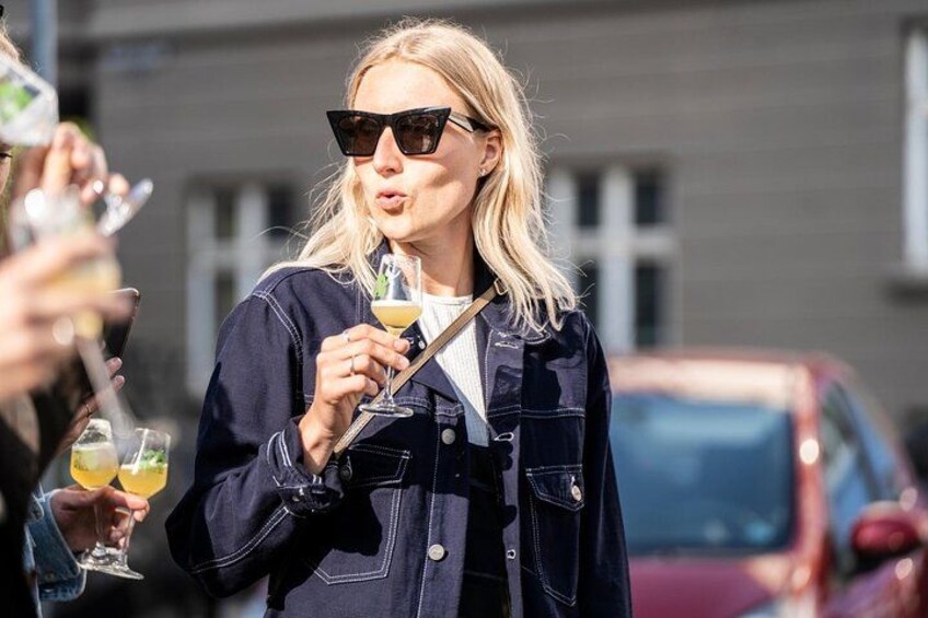 A person wearing a denim jacket holding a drink. 2