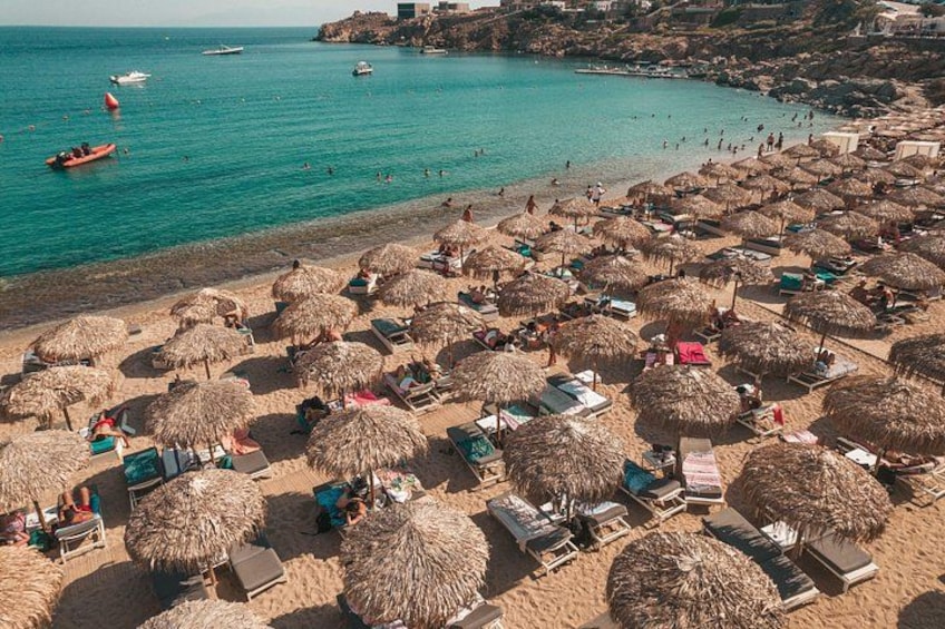 Una playa con sombrillas de paja y sillas de descanso. 2