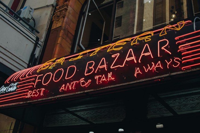 A neon sign for a restaurant named 'Food Bazaar' with a Coca-Cola logo. 3
