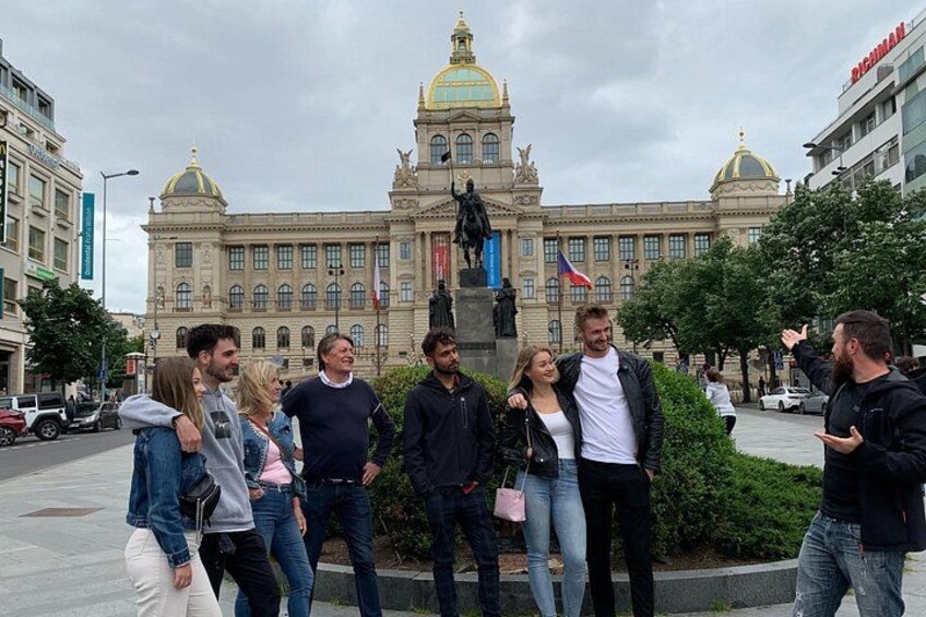 Un grupo de personas de pie frente a un edificio grande con una cúpula dorada y una estatua. 4