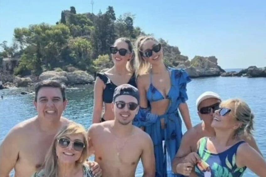 Eine Gruppe von Menschen an einem Gewässer, im Hintergrund felsiges Gelände und Vegetation. 4