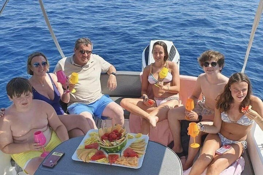 Eine Gruppe von Menschen auf einem Boot mit Essen und Getränken. 3