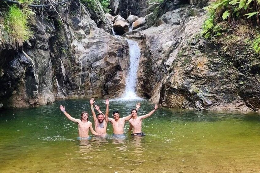 Three people in a natural water setting with a waterfall in the background. 2