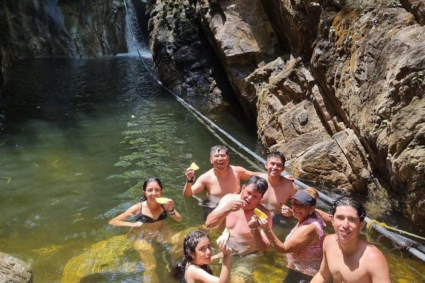 Un grupo de personas en una masa de agua natural rodeada de terreno rocoso. 2
