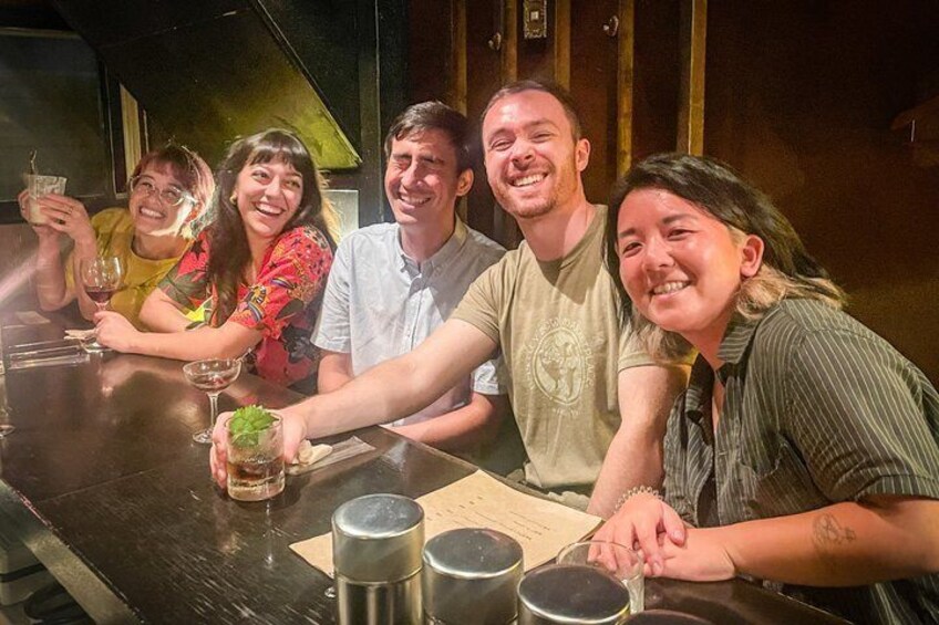 Een groep mensen zit aan een tafel met drankjes en een menukaart. 2