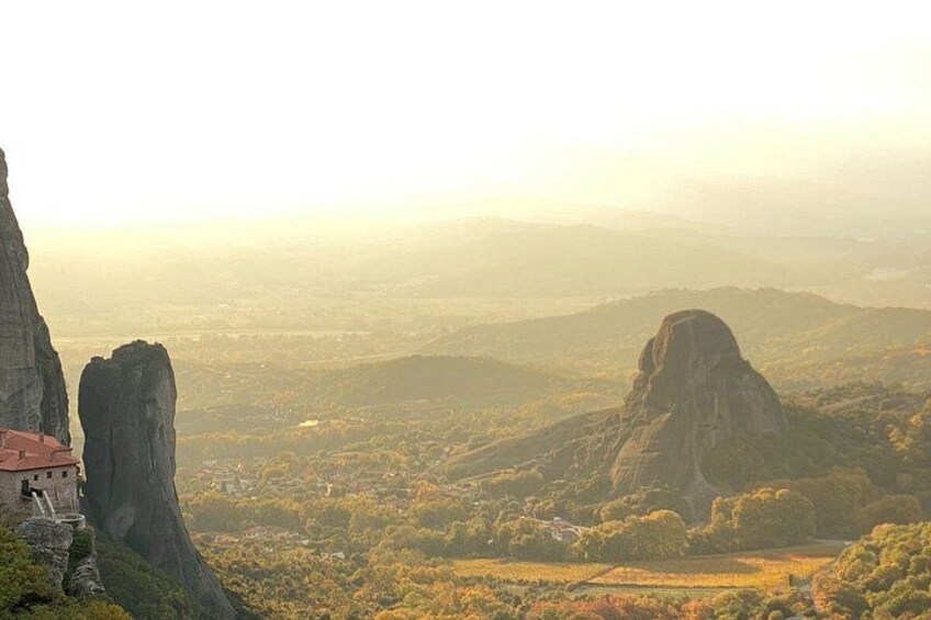A mountainous landscape with a prominent rock formation and a building with a red roof. 3
