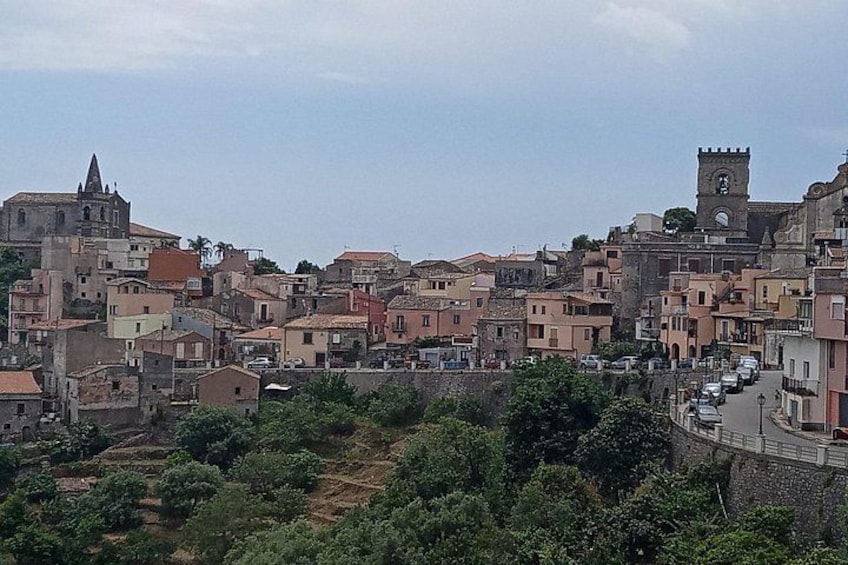 A historic town with a prominent church, a tower, and a winding street. 3