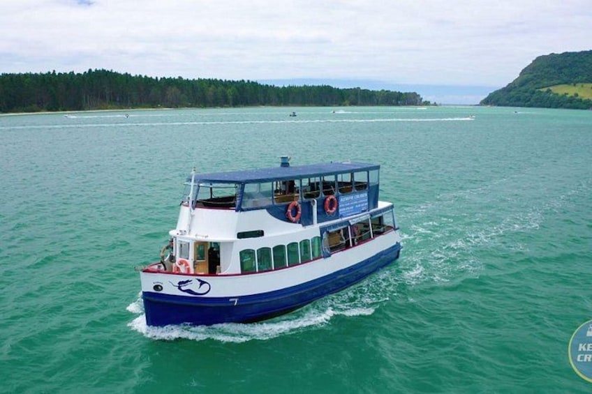 A boat on a body of water with a forested shoreline in the background. 1