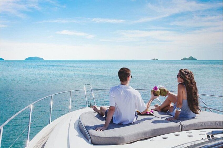A couple on a boat with a view of the sea and distant islands. 5