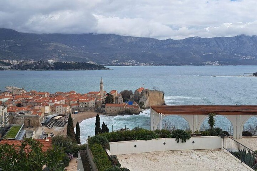 Un pueblo costero con una iglesia destacada, vistas al mar y una cadena montañosa al fondo. 3