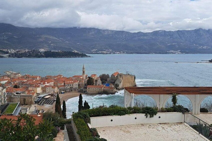 Un pueblo costero con una iglesia destacada, vista al mar y montañas al fondo. 3
