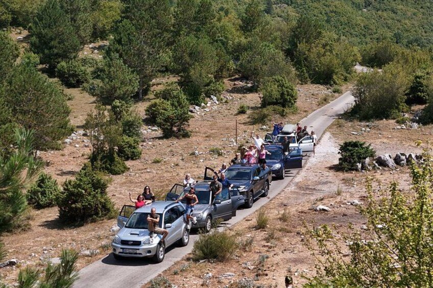 Un grupo de vehículos avanza por un camino de tierra rodeado de vegetación escasa. 5