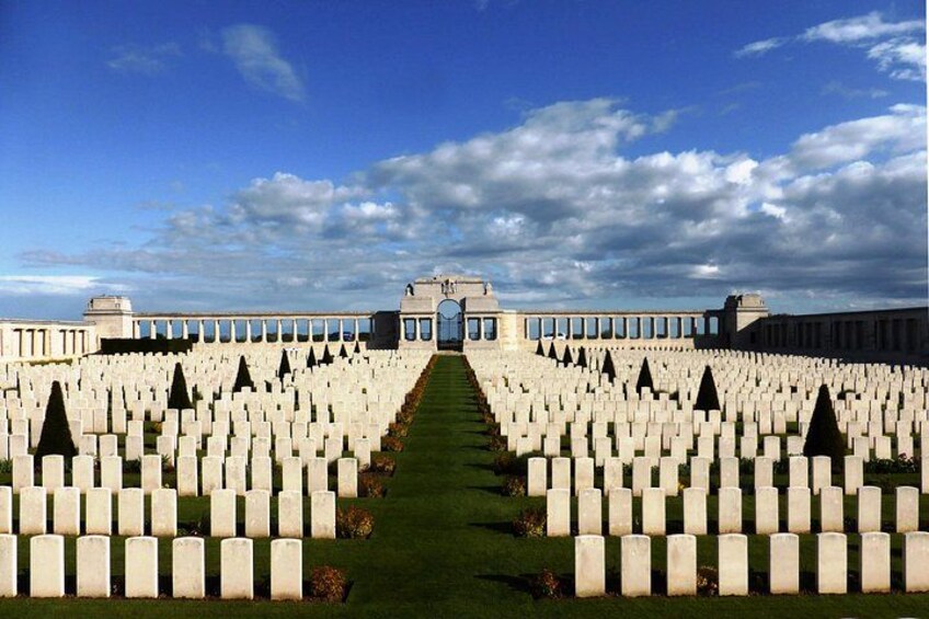 A cemetery with rows of white headstones and a central pathway. 5