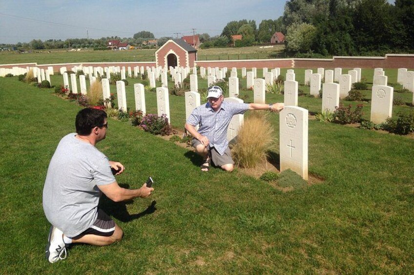 A cemetery with white headstones and a person kneeling next to one. 4