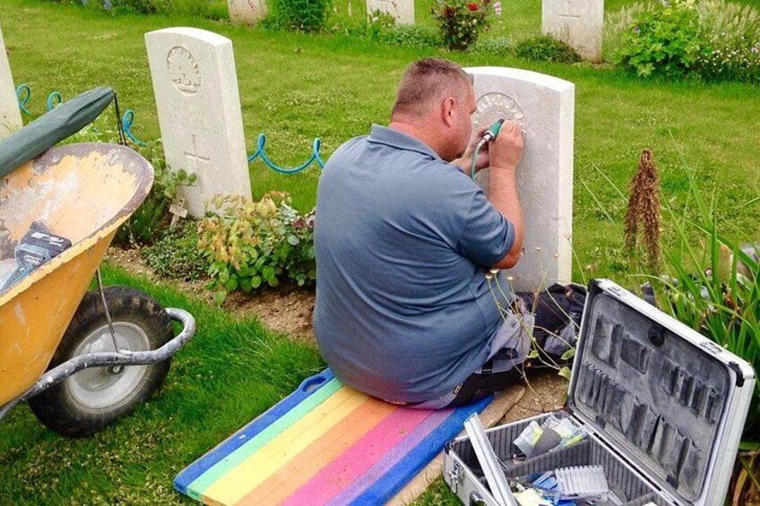 Una persona trabajando en una lápida en un cementerio. 2