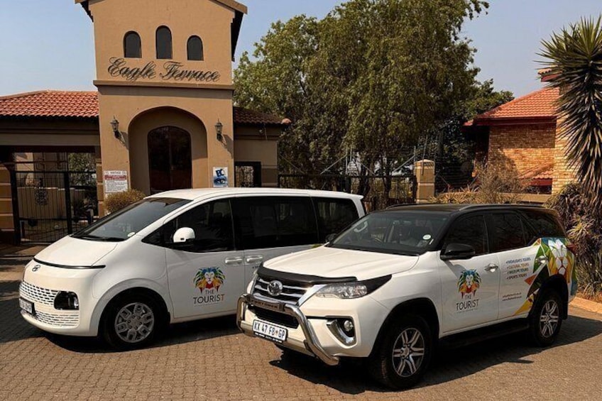 Two white tourist cars parked in front of Eagle Terrace. 2
