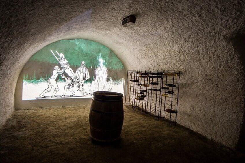 An ice cellar with a barrel and a mural of medieval figures. 1
