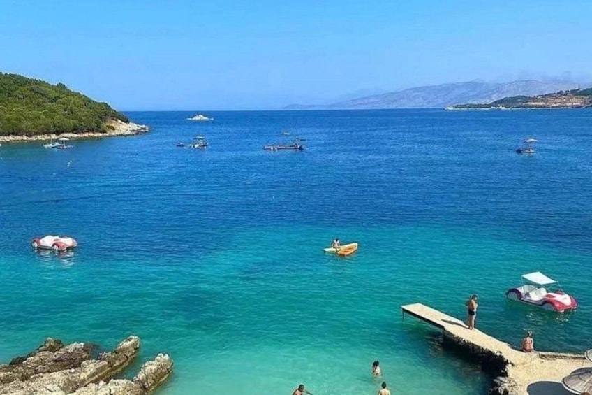 A coastal scene with clear turquoise water, a pier, and boats. 4