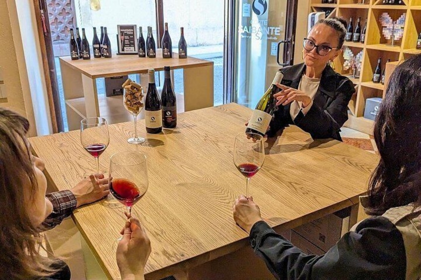 Un grupo de personas en una mesa de madera con copas de vino, una botella y una copa con un peluche. 4