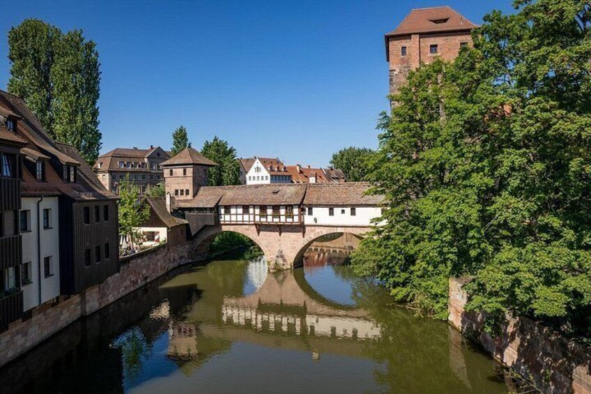 Une rivière avec un pont, des bâtiments et une tour. 2