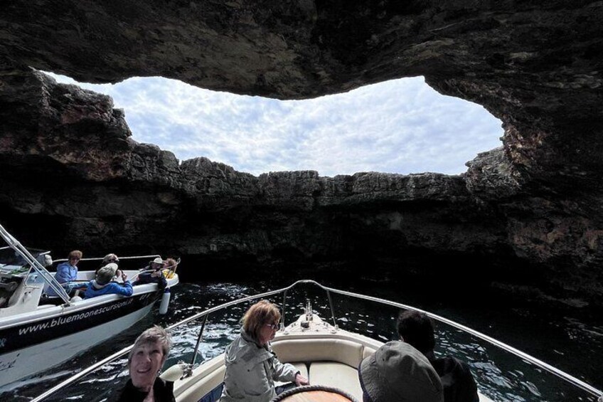 A boat navigating through a rocky arch formation. 5