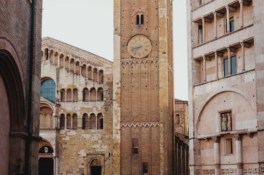 Un bâtiment historique doté d’une tour horlogée, de fenêtres en arc et de motifs complexes en briques. 5