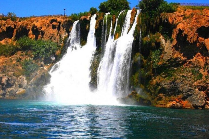 Una cascada de varios niveles que se precipita en una masa de agua rodeada de terreno rocoso. 3