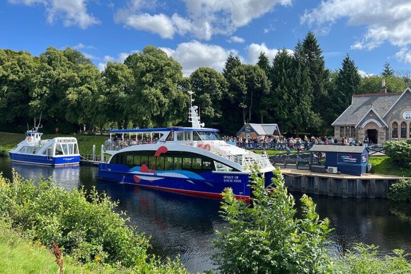 Un bateau bleu et blanc était amarré à un quai, avec une foule rassemblée et un bâtiment en arrière-plan. 2