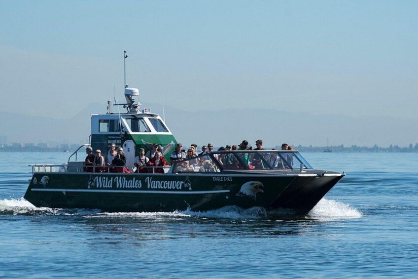 Een boot genaamd 'Wild Whales Vancouver' met passagiers, vaart over het water. 5