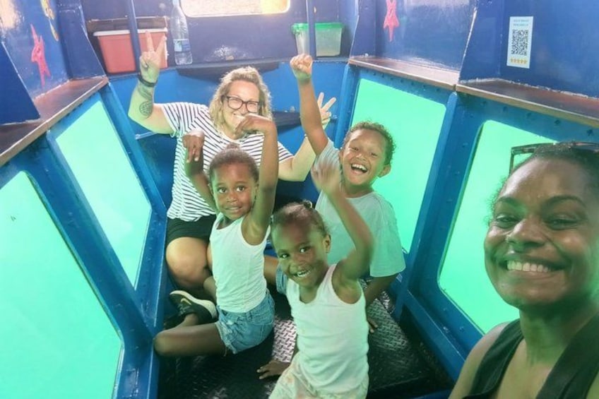 A group of people in a blue and green enclosed ride with a QR code on the wall. 3