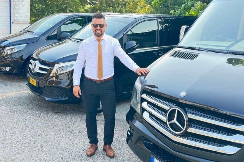 Une personne se tient à côté d’une voiture Mercedes-Benz noire sur un parking. 1